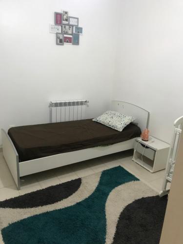 ein Schlafzimmer mit einem Bett und einem grünen Teppich in der Unterkunft Coquelicot Tizi ouzou in Tizi Ouzou