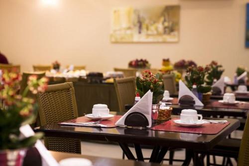 a dining room with tables with napkins on them at Hotel Santos Dumont in Goiânia
