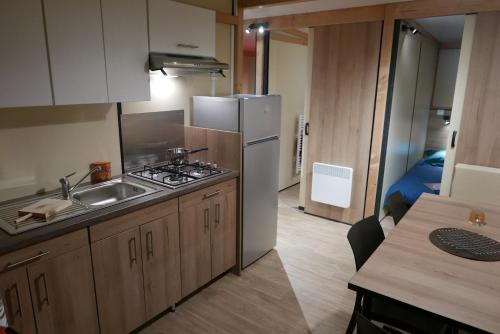 une petite cuisine avec un évier et un réfrigérateur dans l'établissement Camping Le Domaine Des Jonquilles, à Saint-Alban