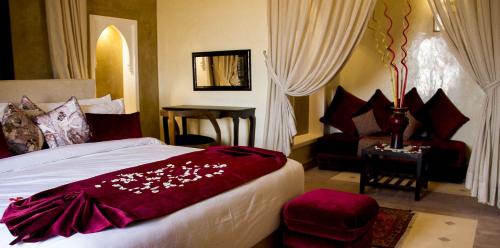 a hotel room with a bed and a chair at Kasbah ATFEL in Ourika