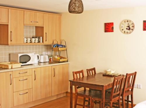 uma cozinha com uma mesa de madeira e uma sala de jantar em The Gremlin Lodge em Brecon