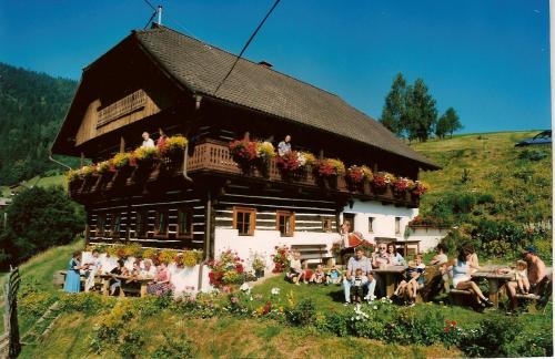 a group of people sitting outside of a house at Bauernhof Oberfriessnig in Radenthein