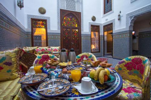 a table with plates of food on it in a room at Dar Fes Tresor in Fès