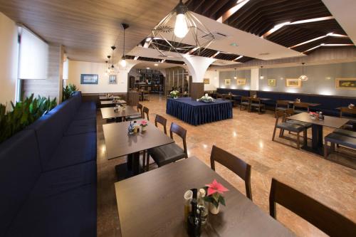 Hotel Zvonimir في أوتوتشاتش: مطعم بطاولات وكراسي وغرفة كبيرة
