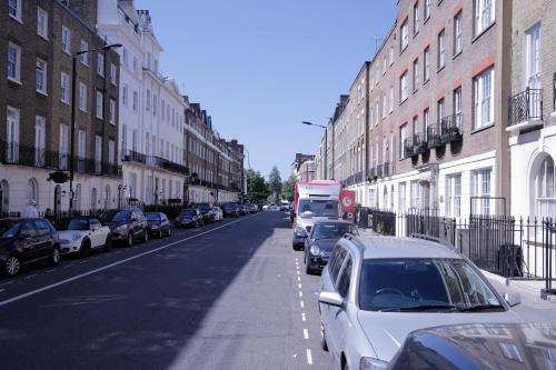 una calle con coches estacionados al costado de la carretera en B&B Belgravia, en Londres