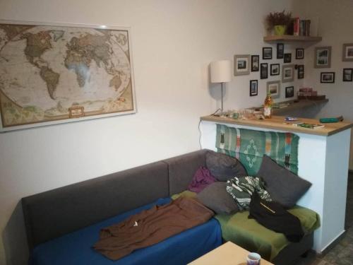 a living room with a couch and a map on the wall at Walbrzych - przytulne, nowe mieszkanie in Wałbrzych