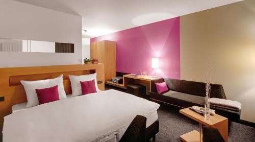 ein Hotelzimmer mit einem Bett und einer Couch in der Unterkunft Spreewald Thermenhotel - Spreewald Therme GmbH in Burg