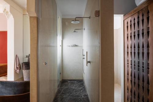 a bathroom with a walk in shower next to a door at 72 Hotel & Spa in Marrakech