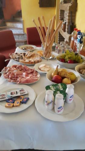 una mesa con platos de comida. en B&B Le Due Rocche, en Maiolo