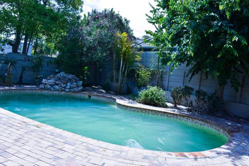 a small swimming pool in a yard with a fence at 34onlincoln Guesthouse in Bellville