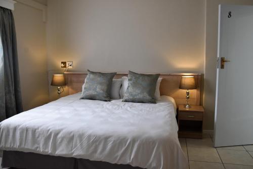 una camera con un letto bianco con due cuscini di 34onlincoln Guesthouse a Bellville