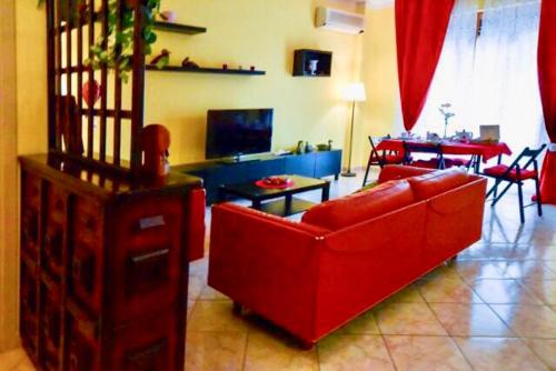 uma sala de estar com um sofá vermelho e uma mesa em B&B La Casa di Isabella Loreto em Loreto