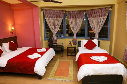 Un pat sau paturi într-o cameră la Hotel Silver Oaks Inn