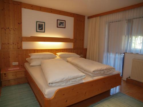 a bedroom with a large bed with white pillows at Beilelers Hof in Arzl im Pitztal