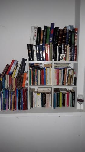 a bunch of books sitting on a white shelf at Trattoria Bar Pace in Re