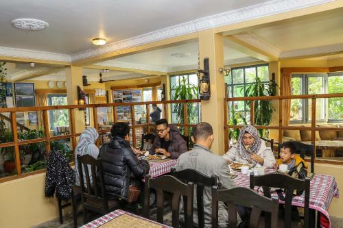 a group of people sitting at a table in a restaurant at Hotel Silver Oaks Inn in Pokhara