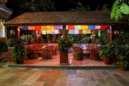 a gazebo with chairs and colorful flags at Hotel Silver Oaks Inn in Pokhara