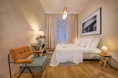 プラハにあるLuxurious Apartments Ujezdのベッドルーム(大きな白いベッド1台、椅子付)