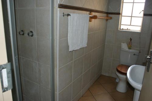 a bathroom with a shower and a toilet and a sink at Eric's Apartments in Centurion