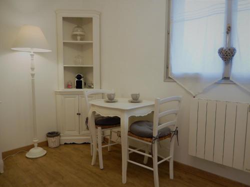 - une petite table et des chaises blanches dans la chambre dans l'établissement La Cordonnerie de Réau, à Réau