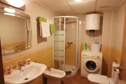y baño con ducha, lavabo y lavadora. en Residencial Almadraba E2, en Águilas