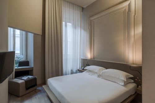 a bedroom with a white bed and a window at Hotel dei Barbieri in Rome