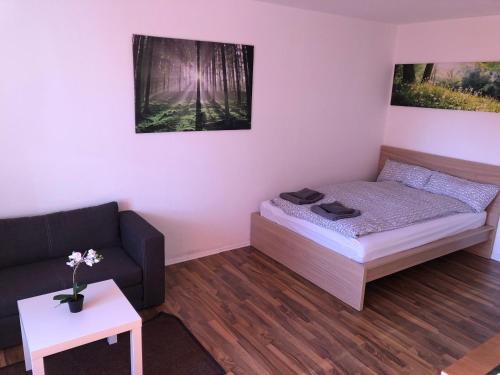 レーゲンスブルクにあるAppartement Redhouseのベッド1台とソファが備わる小さな客室です。