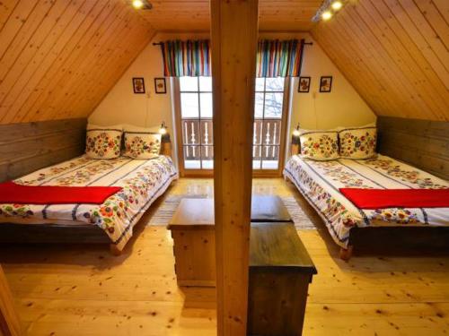 a room with two beds in a cabin with windows at Uroczysko in Brenna