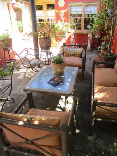 a patio with a table and chairs and potted plants at Hotel Boutique Las Azucenas in Constitución