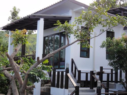 a house with black windows and a tree at High Life Bungalow in Haad Yao