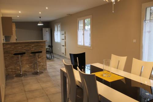 une cuisine et une salle à manger avec une table et des chaises dans l'établissement Le Raboliot, à La Ferté-Saint-Aubin