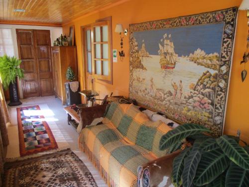 a living room with a couch and a large tapestry at Hotel Boutique Las Azucenas in Constitución