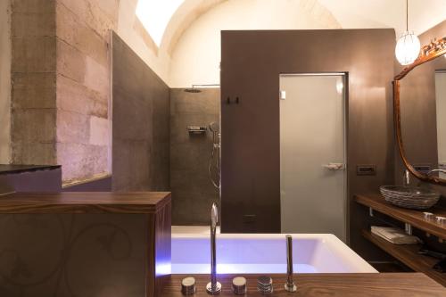 a bathroom with a bath tub with a sink at B&B Giardino Di Pietra in Ragusa
