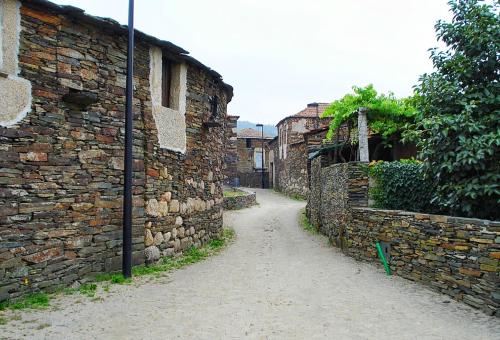 an alley with a stone wall next to a street at Hotel Rural Quinta das Quintães in Penafiel