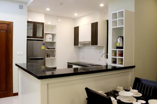 a kitchen with a black counter top and a table at Malis the Residence in Phnom Penh