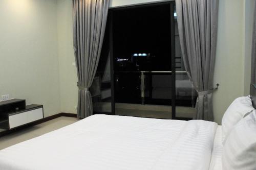 a bedroom with a bed and a large window at Malis the Residence in Phnom Penh