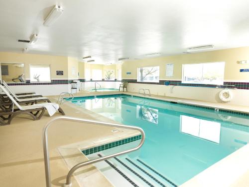 a swimming pool in a hospital room with chairs at Crystal Inn Hotel & Suites - Midvalley in Murray