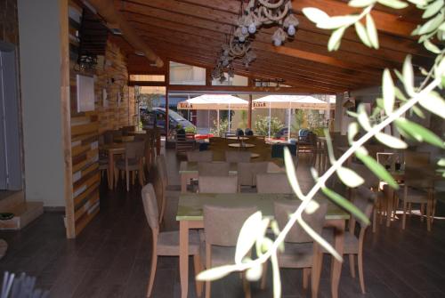 a dining room with a table and chairs and tables and tablesktop at Olive Tree in Sarandë