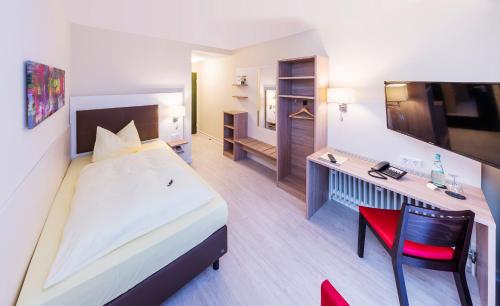 um quarto de hotel com uma cama grande e uma secretária em Montana Landhotel Gummersbach-Nord em Marienheide