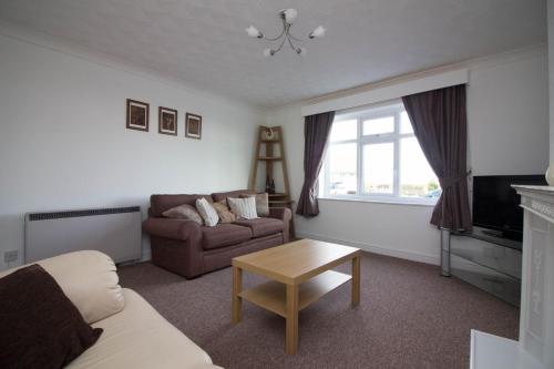 a living room with a couch and a table at Lovely Sea Front House in Cleethorpes on Beachfront sleeps up-to 6 in Cleethorpes