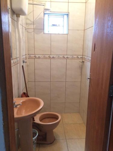 a bathroom with a toilet and a sink and a window at Casa da Pirâmide in São Thomé das Letras
