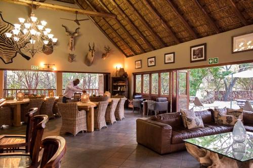 Pretoria的住宿－Izapa Bush And Game Lodge，餐厅设有带沙发和桌子的酒吧