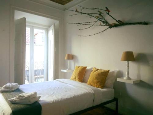 a bedroom with a bed and a lamp on the wall at De Pedra e Sal Hostel & Suites in Setúbal