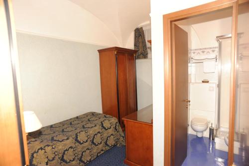 Dormitorio pequeño con cama y aseo en Hotel Silva en Roma