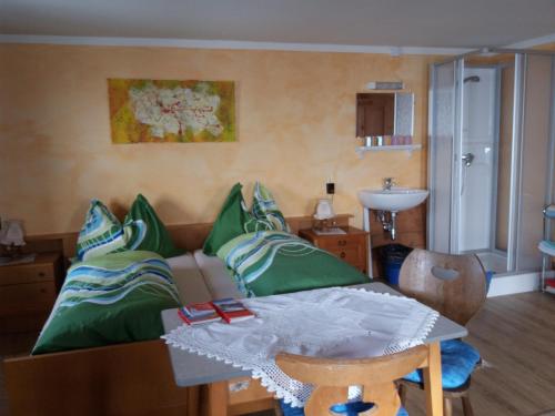 ein Wohnzimmer mit einem Sofa und einem Tisch mit grünen Kissen in der Unterkunft Talhof in Jochberg