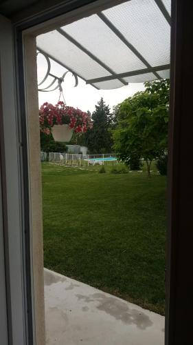 una ventana con vistas a un patio con una maceta de flores en Gite Pourquoi Pas, en Montégut-Lauragais