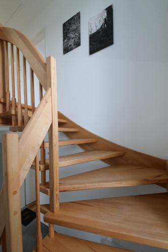 a wooden staircase in a room with two pictures on the wall at Ferienhaus Caputh in Caputh
