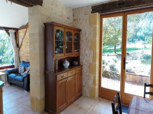 a living room with a wooden cabinet and a window at Les Coustilles in Saint-Alvère