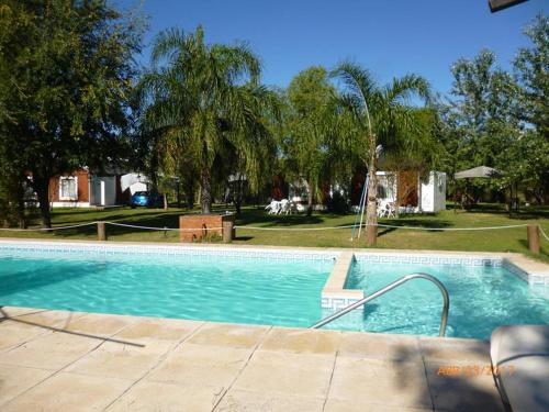 a swimming pool in a yard with trees at Cabañas Los Girasoles in Gualeguaychú