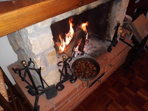 a brick fireplace with a fire in it at Appartamento Lucia in Pescocostanzo